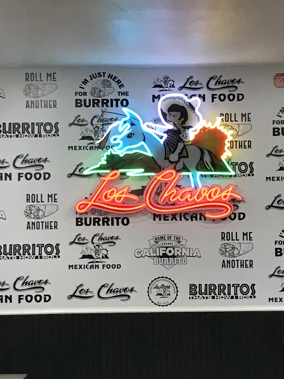 Los Chavos neon logo on a printed restaurant wall