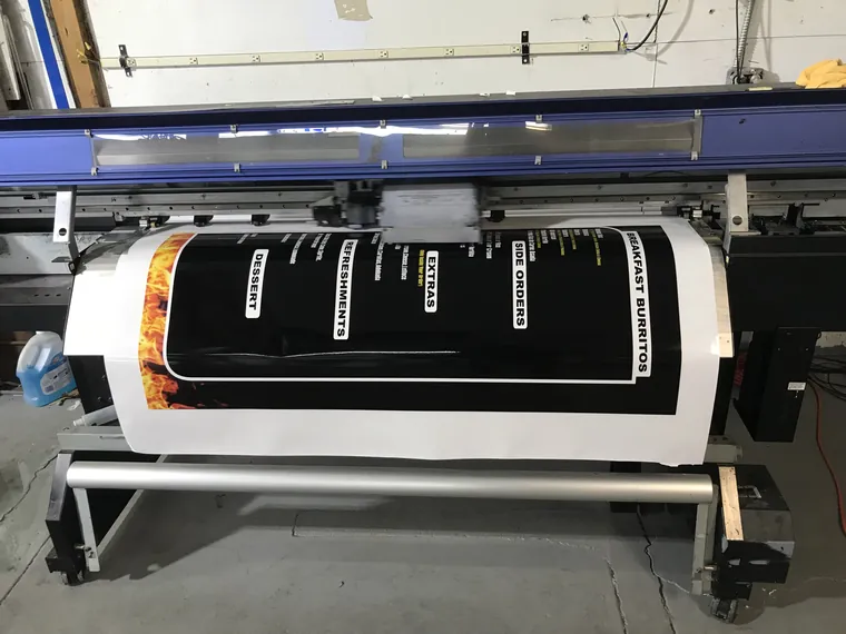 Large-format printer printing a menu board