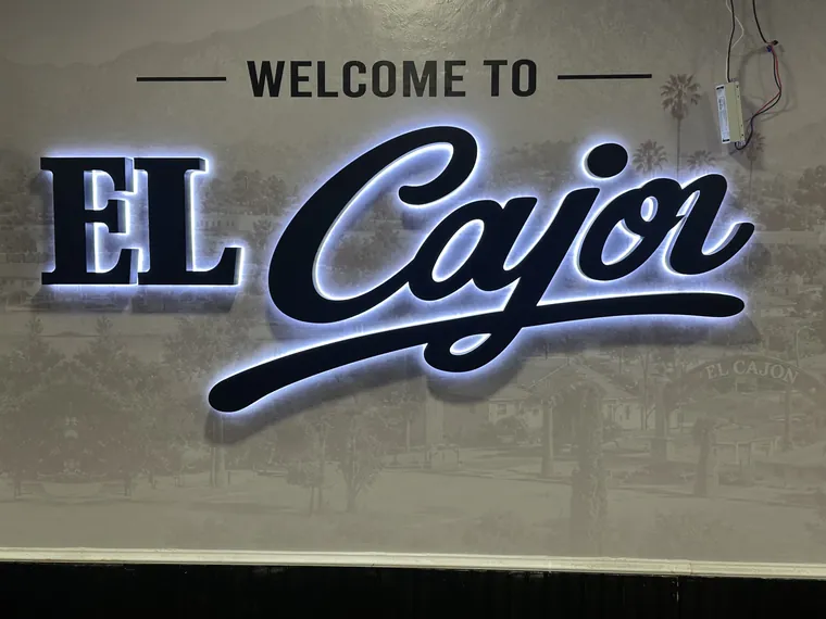 Welcome to El Cajon letters with a white halo on a printed wall