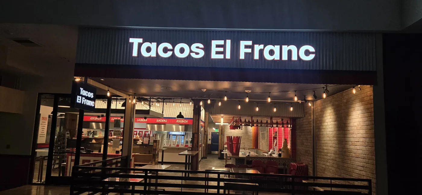 Tacos El Franc illuminated storefront letters at night