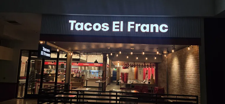 Tacos El Franc illuminated storefront letters at night