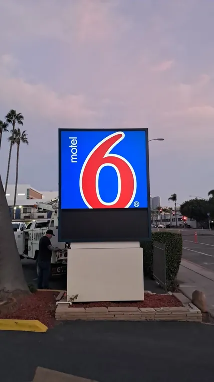 Motel 6 illuminated monument sign at dusk