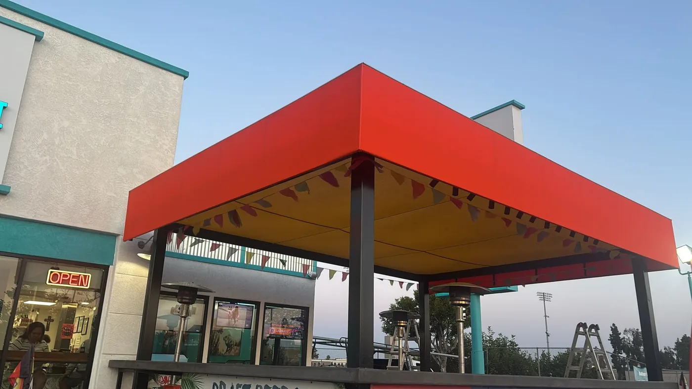 Red patio cover with a yellow underside outside a restaurant
