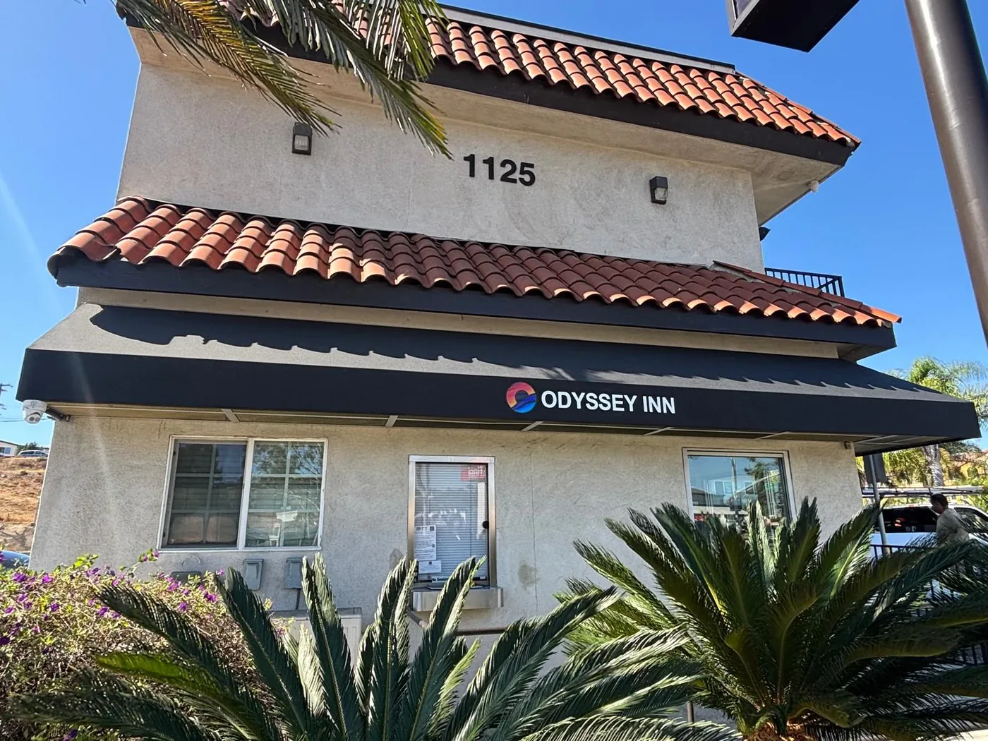 Odyssey Inn black awning with the name and logo