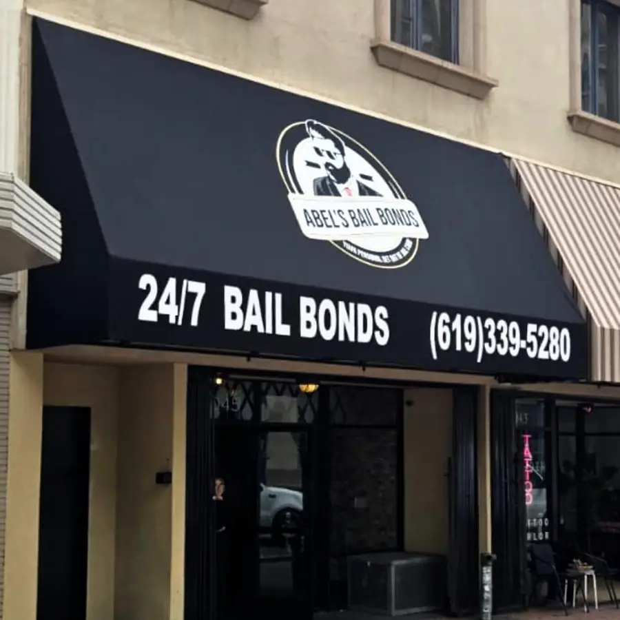 Black storefront awning for Abels Bail Bonds with lettering and phone number