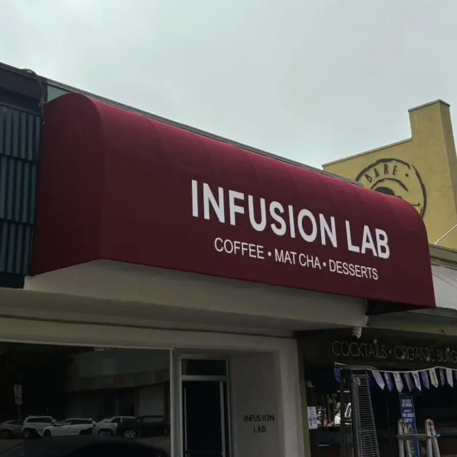 Dark red Infusion Lab awning over a coffee shop entrance