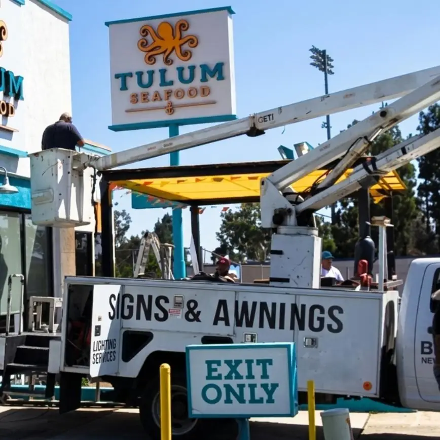 Best Deal bucket truck installing a yellow patio cover at Tulum Seafood