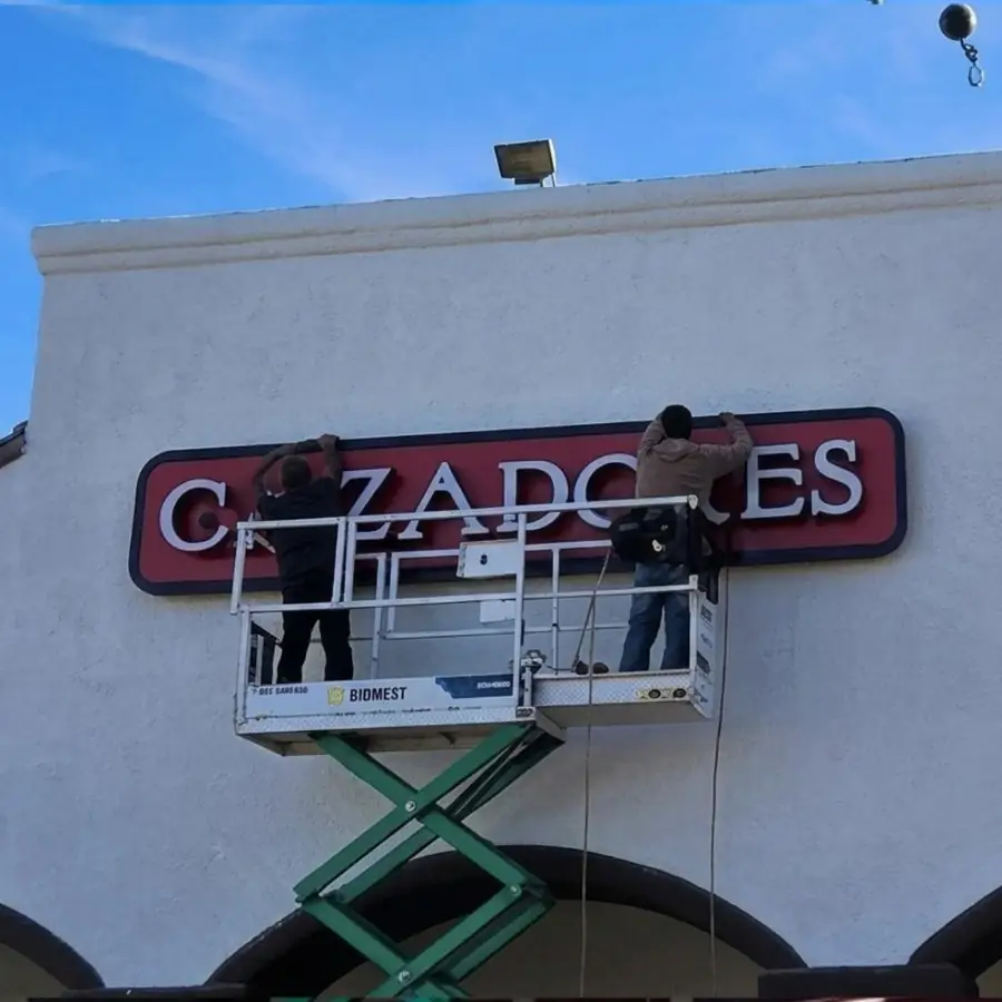 Crew installing Cazadores channel letters from a scissor lift