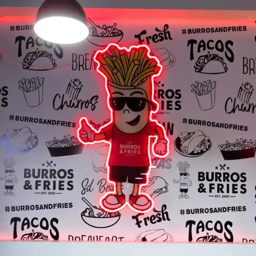 Burros and Fries mascot neon sign on a printed pattern wall