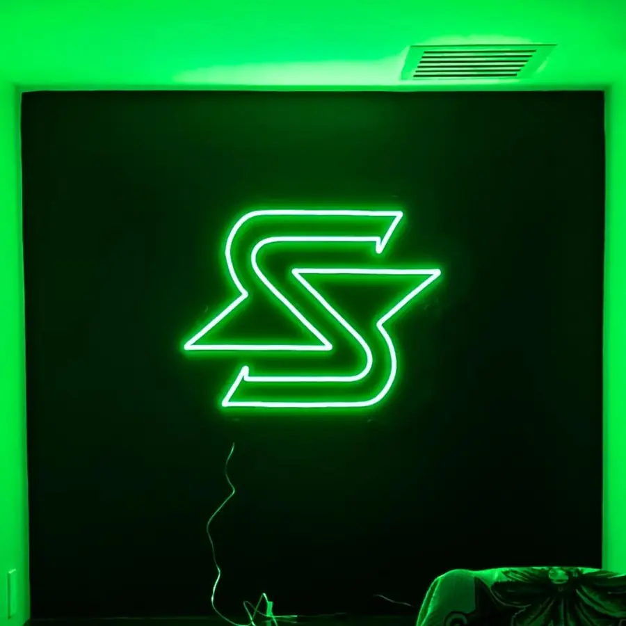 Green S logo neon sign glowing on a dark panel