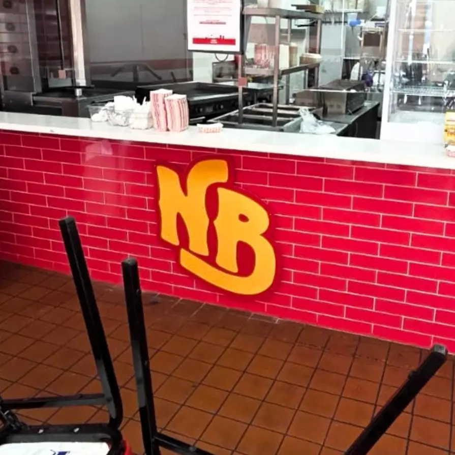 National Burrito NB monogram on a red brick interior wall