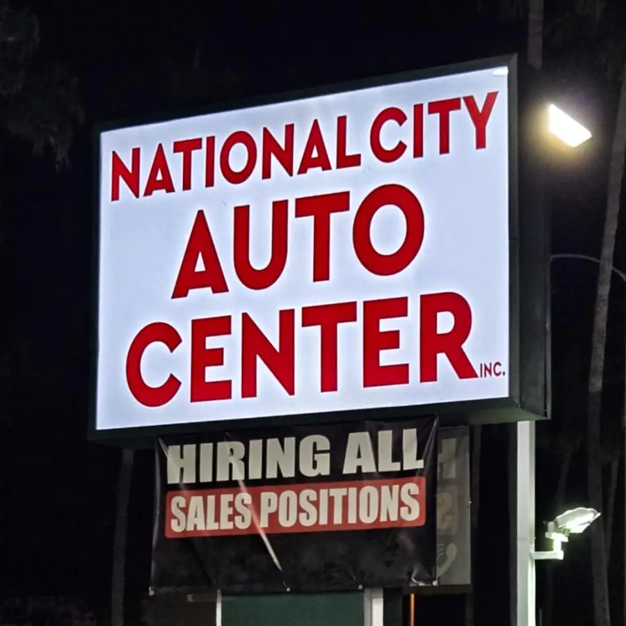 National City Auto Center lit sign with a hiring message panel