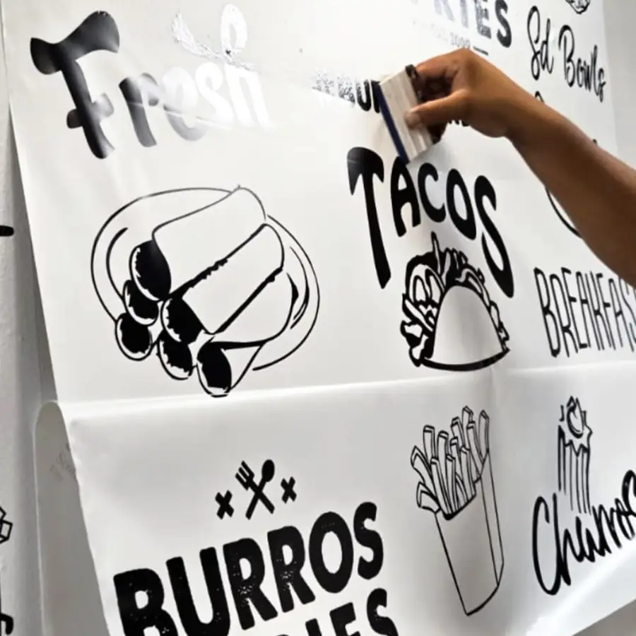 Installer smoothing a printed Fresh Burros and Tacos decal