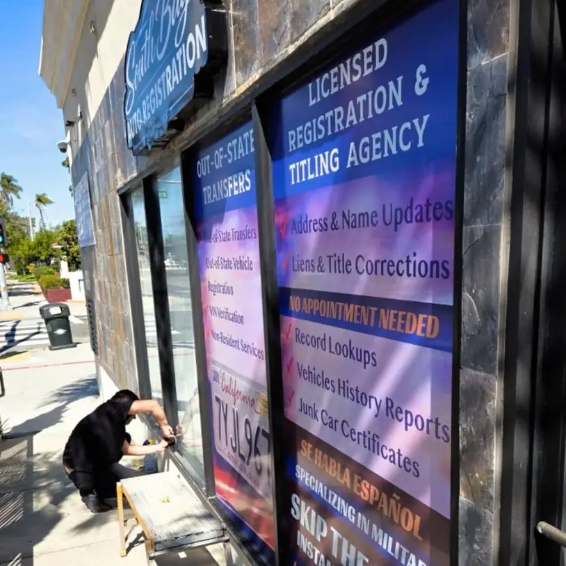 Installer fitting printed window panels at South Bay Auto Registration