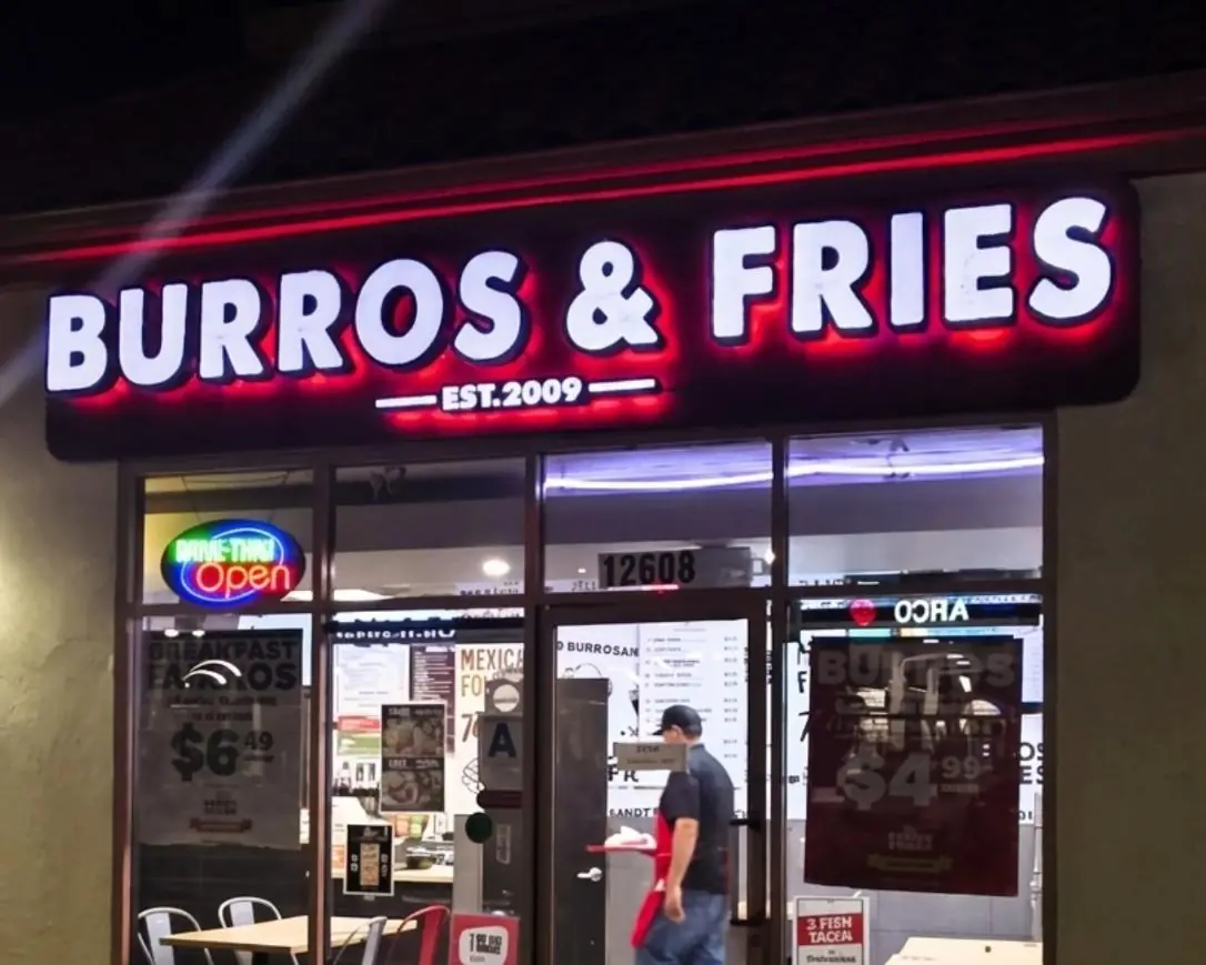 Burros and Fries storefront with illuminated channel letters at night