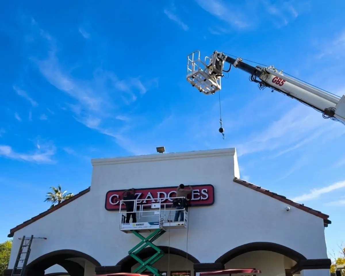 Best Deal crew lifting a Cazadores Mexican Grill sign into place with a crane