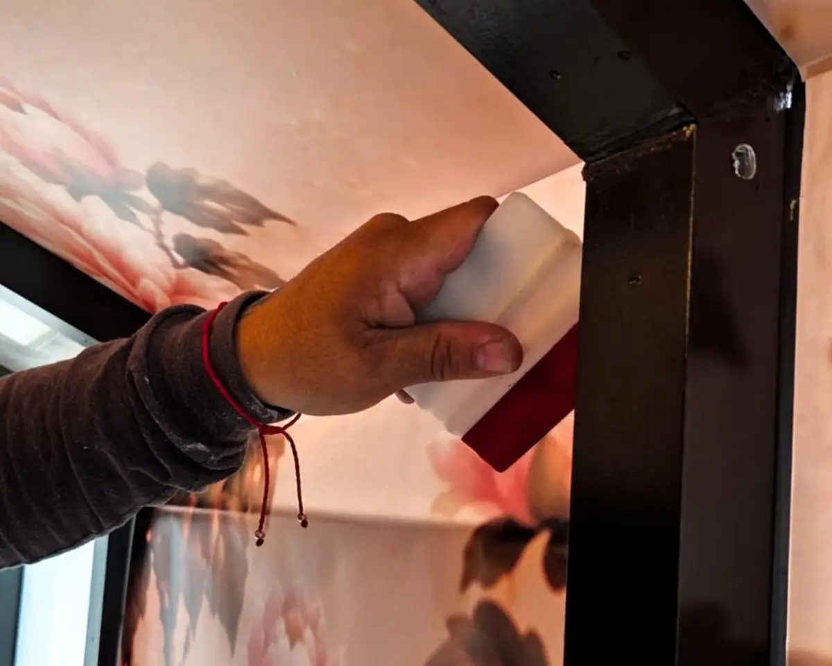 Installer squeegeeing a floral wall mural into place
