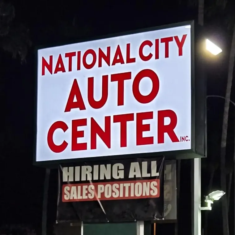 National City Auto Center lit sign with a hiring banner below it